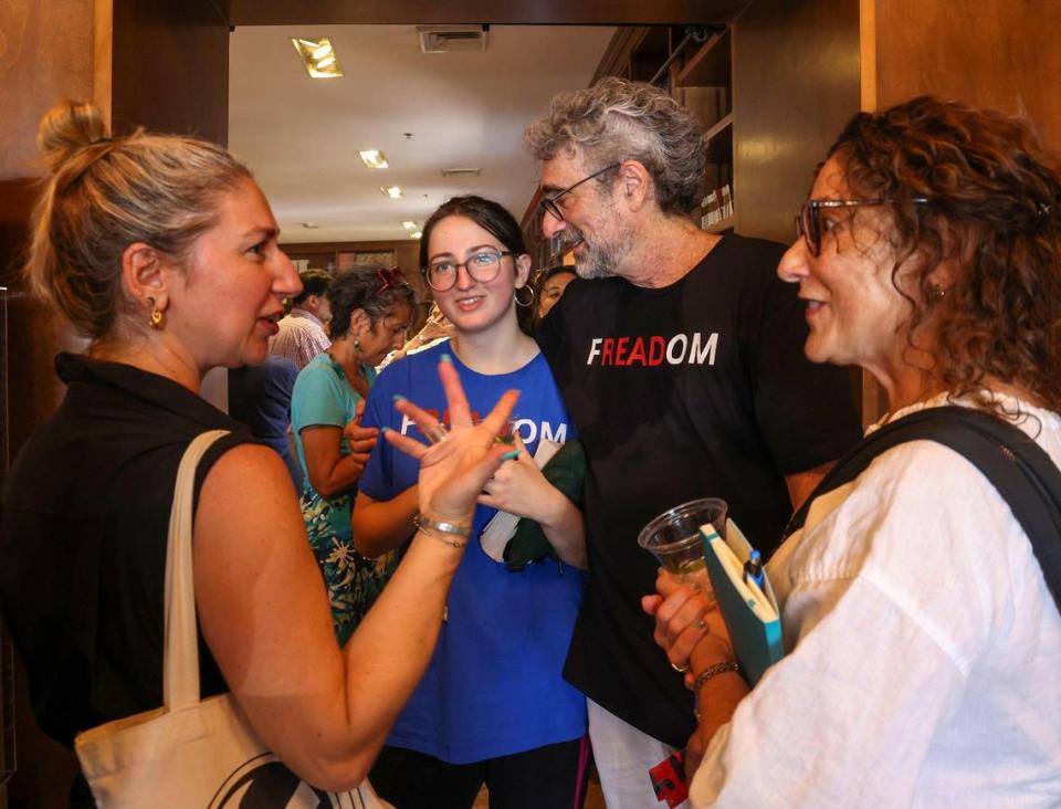 El propietario de Books & Books, Mitchell Kaplan (centro-derecha), habla con la estudiante de secundaria Iris Mogul (centro-izquierda), que fundó un club de libros prohibidos, durante el acto inaugural de la "Marcha por la libertad", el domingo 1º de octubre de 2023, en Coral Gables, Florida. La marcha comenzó en la Coral Gables Congregational United Church of Christ y terminó en Books & Books.