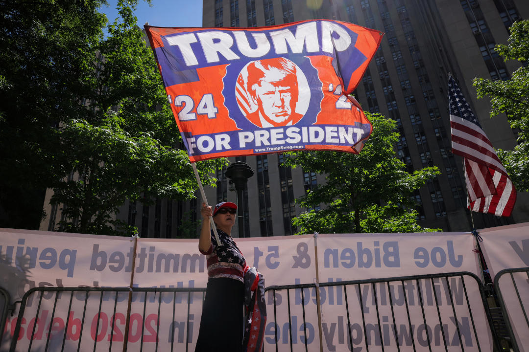 A demonstrator holds a flag that reads: Trump for President '24.