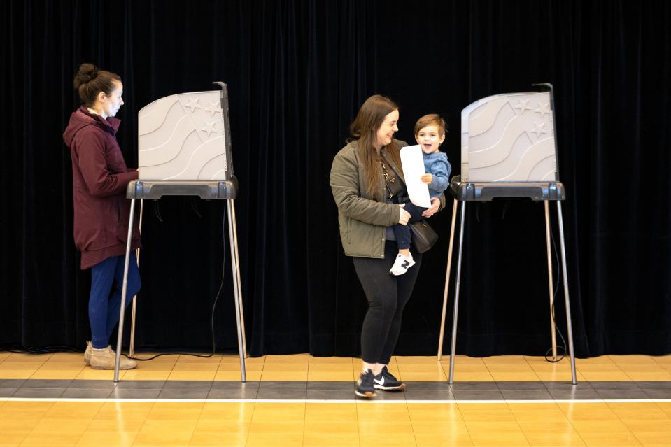 Chelsey Jones holds her 2-year-old son, Asher, after she voted Tuesday at the Bryn Du Fieldhouse in Granville.