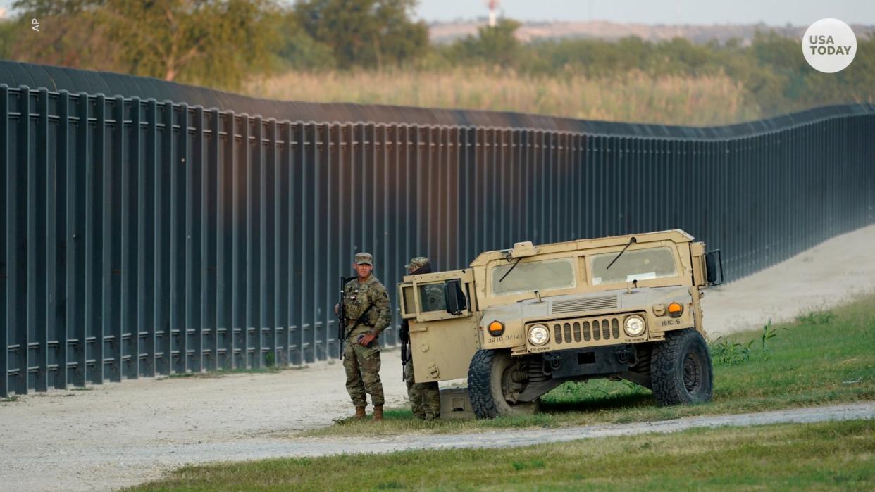 National Guardsmen stand watch over a fence near the International Bridge in Del Rio, Texas. Texas Gov. Greg Abbott has ordered thousands of Guardsmen to help patrol the Texas-Mexico border.