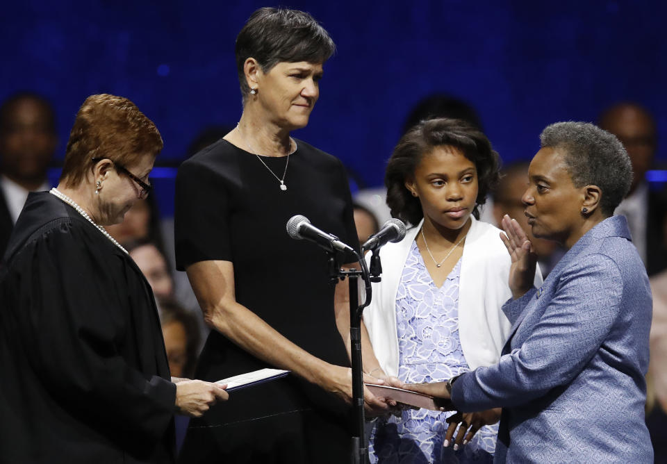 Mayor of Chicago Lori Lightfoot, right, takes her oath from U.S. District Court Magistrate Judge Susan E. Cox, left as her spouse Amy Eshleman, second left, and her daughter Vivian look during her inauguration ceremony Monday, May 20, 2019, in Chicago. (AP Photo/Jim Young)