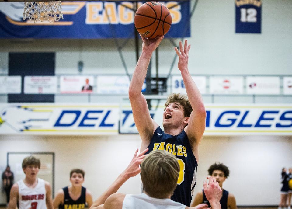 Delta's Jackson Wors shoots over a Wapahani defender during their championship game at Delta High School Saturday, Jan. 15, 2022.