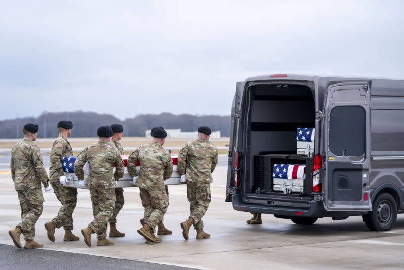 A U.S. Army carry team salutes as a transfer case carrying the remains of Army Sgt. Kennedy Sanders is loaded into a transfer vehicle during a dignified transfer at Dover Air Force Base in Dover, Del., on Friday. Photo by Bonnie Cash/UPI