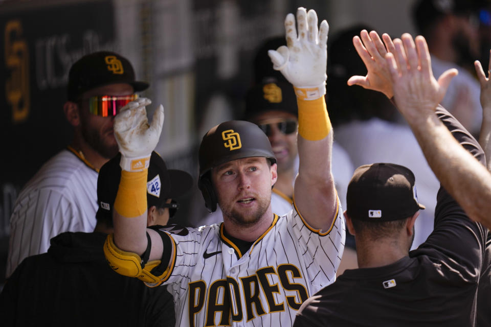 San Diego Padres' Jake Cronenworth celebrates with teammates in the dugout after hitting a two-run home run during the fifth inning of a baseball game against the Milwaukee Brewers, Saturday, April 15, 2023, in San Diego. (AP Photo/Gregory Bull)