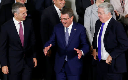 (L-R) NATO Secretary-General Jens Stoltenberg, U.S. Defense Secretary Ashton Carter and Britain's Defence Secretary Michael Fallon pose for a family photo during a NATO defence ministers meeting at the Alliance headquarters in Brussels, Belgium, October 26, 2016. REUTERS/Francois Lenoir