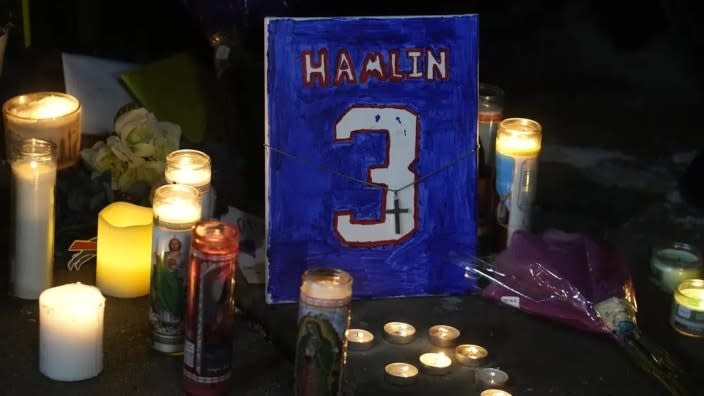 A painting that shows the number of Buffalo Bills’ Damar Hamlin is illuminated by candles during a prayer vigil outside University of Cincinnati Medical Center Tuesday night in Cincinnati. Hamlin was taken to the hospital after collapsing on the field during an NFL football game against the Cincinnati Bengals the previous night. (Photo: Darron Cummings/AP)