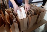 A chef from the St Giles Trust Brewbird cafe, prepares hot food packages for people in need of free school meals, in London