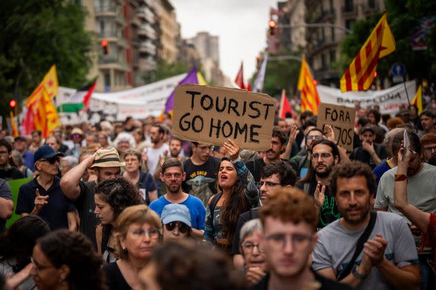 Demonstrators march and shout slogans on June 19 in protest of the Formula One Barcelona Fan Festival in downtown Barcelona. About 500 Barcelona residents protested mass tourism at an exhibition of the Formula One cars.