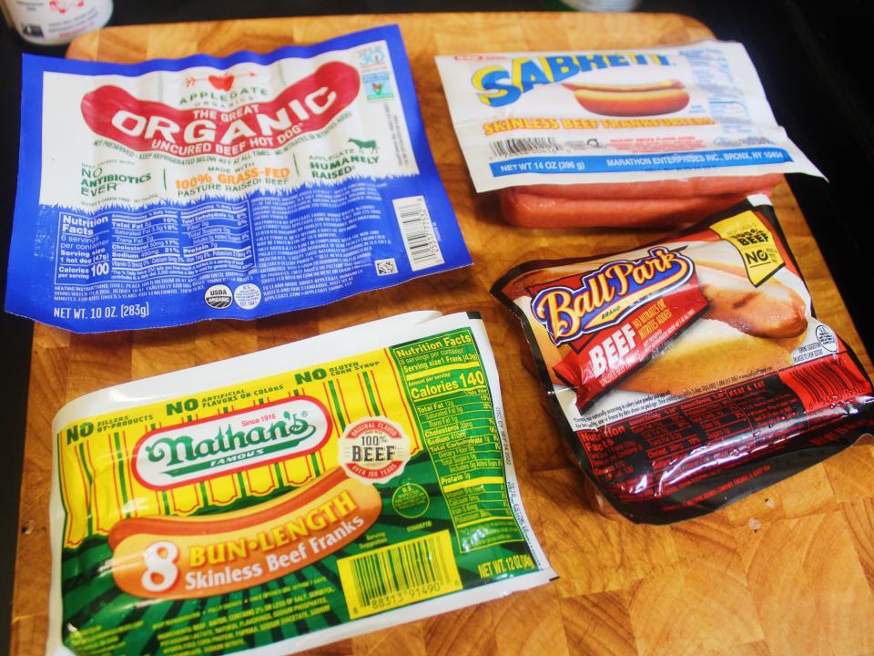 different hot dog brands on a wooden cutting board
