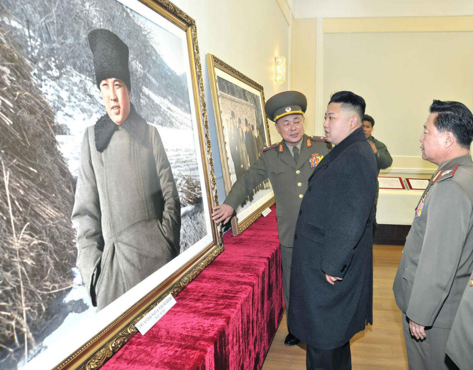 This undated photo released by North Korea's official Korean Central News Agency via the Korean News Service on March 25, 2013 shows North Korean leader Kim Jong-Un (C) looking a photo of President Kim Il Sung during an inspection at the Victorious Fatherland Liberation War Museum at an undisclosed location in North Korea.