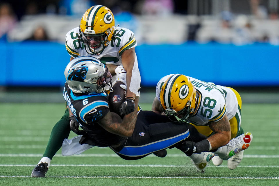 Carolina Panthers running back Miles Sanders is tackled by Green Bay Packers safety Anthony Johnson Jr. (36) and linebacker Isaiah McDuffie (58) during the second half of an NFL football game Sunday, Dec. 24, 2023, in Charlotte, N.C. (AP Photo/Rusty Jones)