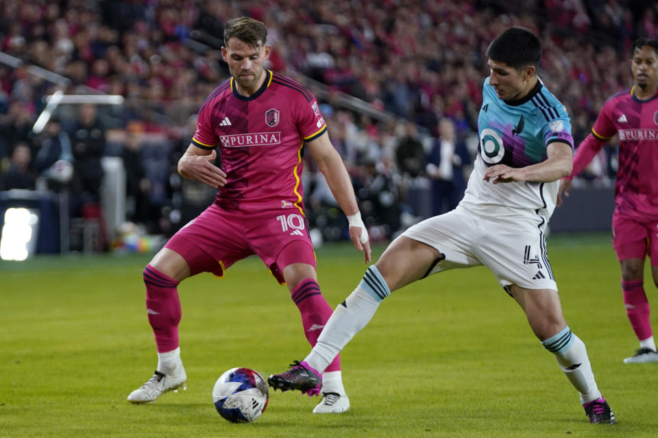 St. Louis City's Eduard Lowen (10) and Minnesota United's Miguel Tapias (4) battle for the ball during the second half of an MLS soccer match Saturday, April 1, 2023, in St. Louis. (AP Photo/Jeff Roberson)