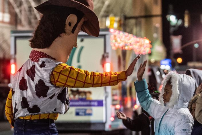 Woody, from Toy Story, high fives children while walking down E Main Street during the annual Jackson-Madison County Christmas Parade on Monday, Dec 6, 2021 in downtown Jackson, with the theme &quot;Christmas: Yesterday, Today, and Tomorrow.&quot; 