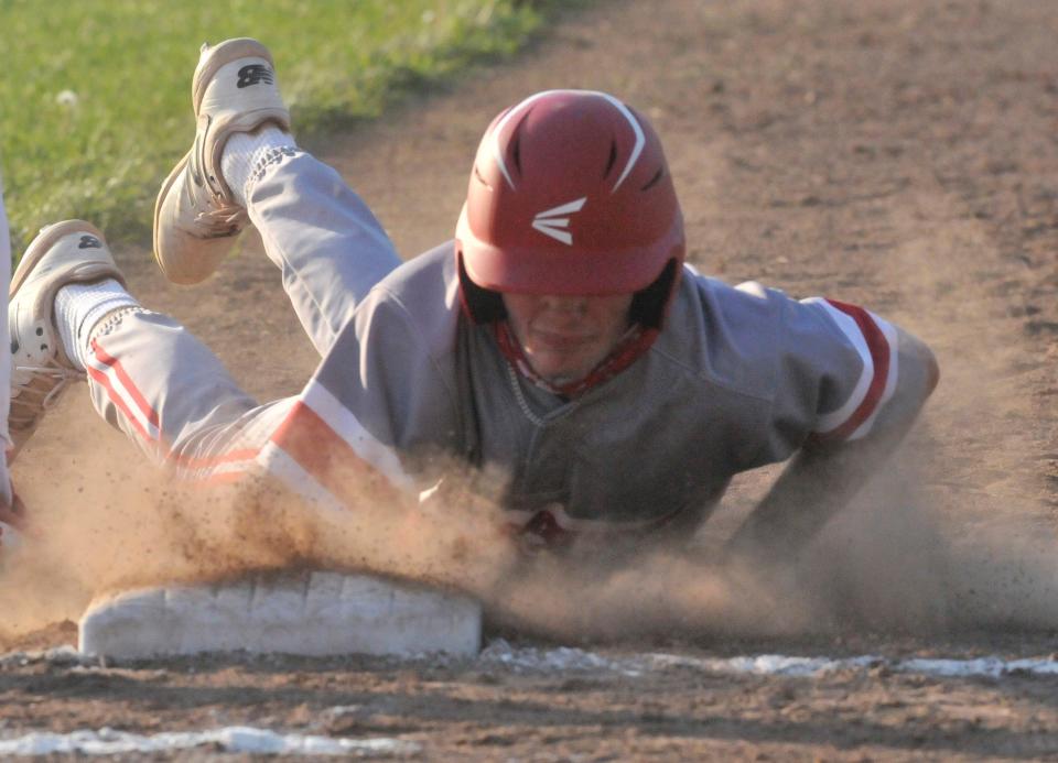 Canandaigua's Sam Boock dives safely back to first base to avoid being picked off by Fairport.