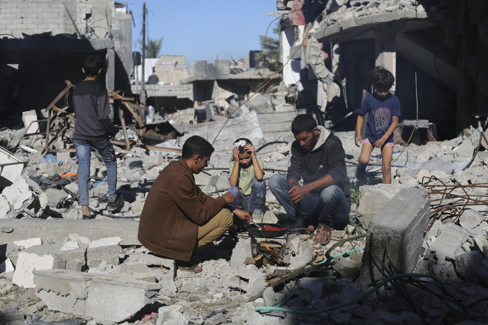 Palestinians cook bread by their destroyed homes in Kuza' a Gaza Strip during the temporary ceasefire between Hamas and Israel on Wednesday, Nov. 29, 2023. AP Photo/Hatem Ali)