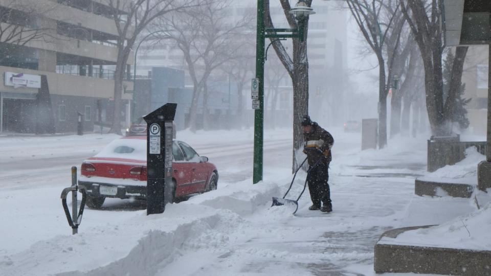 A person shovels snow during the snowstorm in downtown Saskatoon on Saturday afternoon. (Liam O'Connor/CBC - image credit)