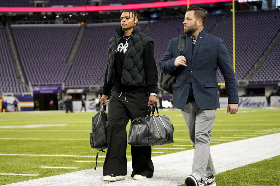 Chicago Bears quarterback Justin Fields, left, arrives at U.S. Bank Stadium before an NFL football game against the Minnesota Vikings, Monday, Nov. 27, 2023, in Minneapolis. (AP Photo/Abbie Parr)