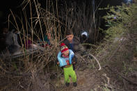 FILE - In this March 28, 2021, file photo, an infant weeps as he is unloaded from an inflatable raft after being smuggled into the United States by crossing the Rio Grande River in Roma, Texas. Roma, a town of 10,000 people with historic buildings and boarded-up storefronts in Texas' Rio Grande Valley, is the latest epicenter of illegal crossings, where growing numbers of families and children are entering the U.S. to seek asylum. So many children are coming that there's little room in long-term care facilities, where capacity shrank significantly during the coronavirus pandemic. (AP Photo/Dario Lopez-Mills, File)