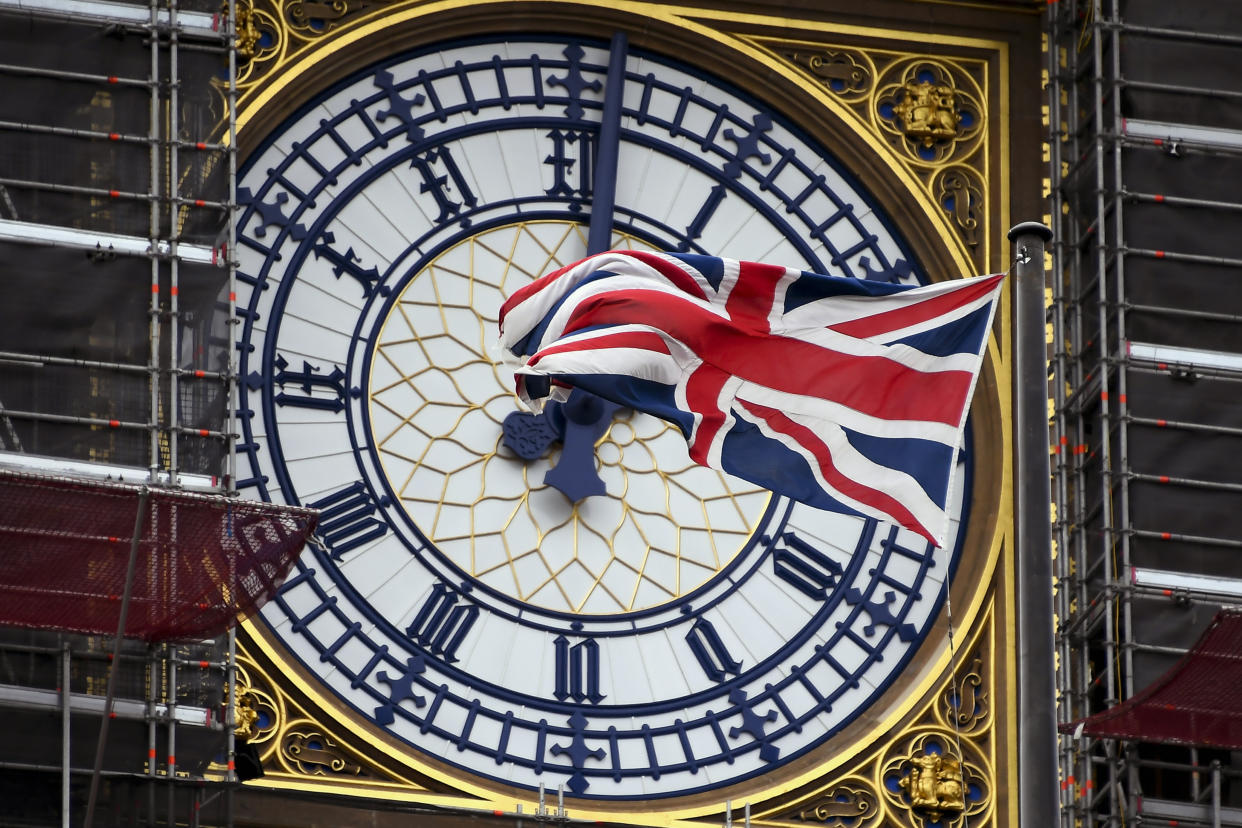 Una bandera de Gran Bretaña ondea ante la fachada del reloj de la Torre Isabel, conocida como Big Ben, en Londres, el viernes 1 de noviembre de 2019. (AP Foto/Alberto Pezzali)