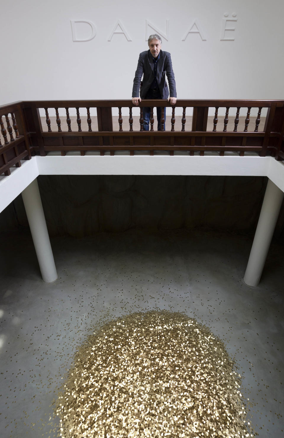 In this photo taken on Tuesday, May 28, 2013 artist Vadim Zakharov poses with his installation 'Danae' in the Russian Pavilion during a press preview of the 55th edition of the Venice Biennale of Arts in Venice, northern Italy. (AP Photo/Domenico Stinellis)