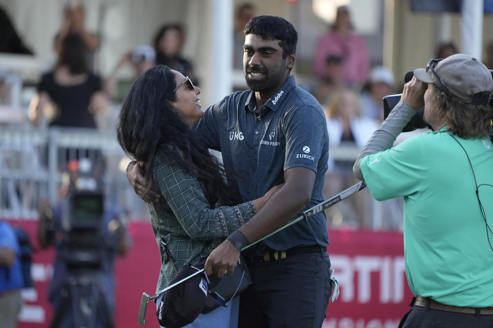 Sahith Theegala, center, is greeted by his mother Karuna Theegala, left, on the 18th green of the Silverado Resort North Course after winning the Fortinet Championship PGA golf tournament in Napa, Calif., Sunday, Sept. 17, 2023. (AP Photo/Eric Risberg)