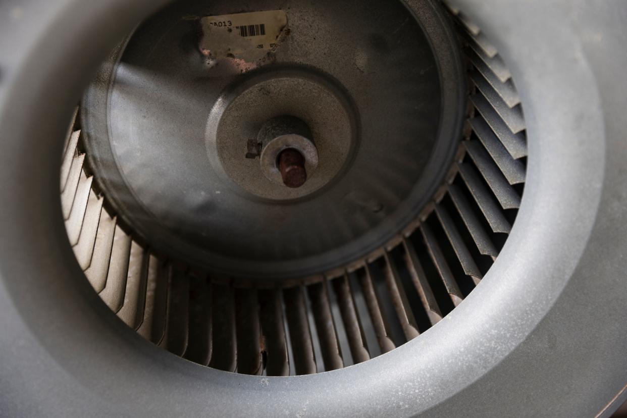 The blower housing of the HVAC unit after it has been removed from the system and taken outside for cleaning. The biological growth that had formed on the white sticker has been removed, and the blades inside the unit have been cleaned.