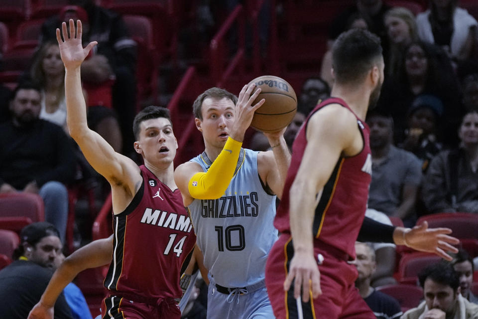 Memphis Grizzlies guard Luke Kennard (10) looks to pass the ball while defended by Miami Heat guard Tyler Herro (14) during the first half of an NBA basketball game Wednesday, March 15, 2023, in Miami. (AP Photo/Rebecca Blackwell)