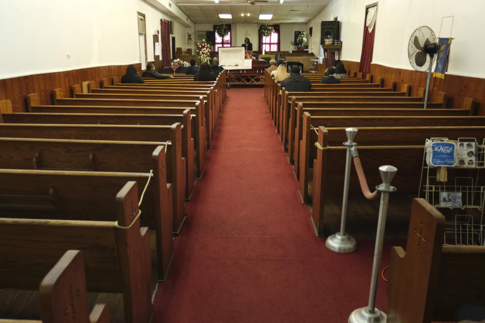 Un reducido número de personas asisten al funeral de Mattie Halley Robinson el sábado 2 de mayo de 2020 en la iglesia de Dios en Cristo en Jersey City, Nueva Jersey. Diversas familias han tenido que homenajear a sus muertos desde lejos y en pequeños grupos en los actuales tiempos del distanciamiento social. (AP Foto/Seth Wenig)