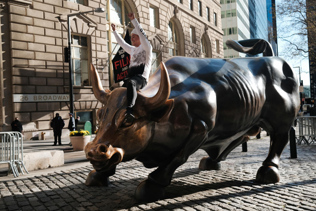 NEW YORK, NEW YORK - NOVEMBER 24: A man sits on the Wall street bull near the New York Stock Exchange (NYSE) on November 24, 2020 in New York City. As investor's fear of an election crisis eases, the DowJones Industrial Average passed the 30,000 milestone for the first time on Tuesday morning.  (Photo by Spencer Platt/Getty Images)