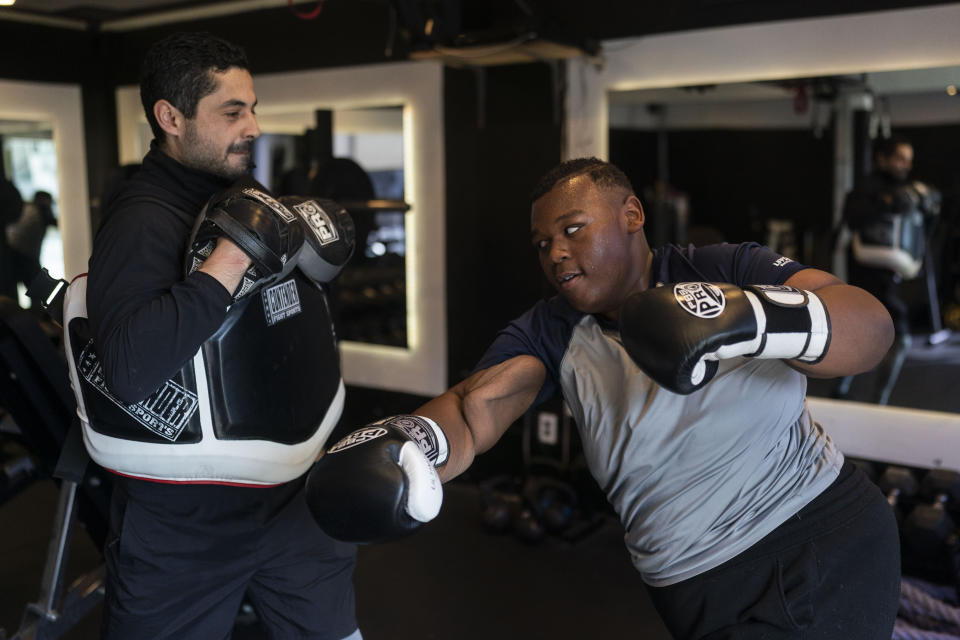 John Simon, a teenager who had a bariatric surgery in 2022, exercises with his trainer Chris Robles at El Workout Fitness in Los Angeles, Monday, March 13, 2023. (AP Photo/Jae C. Hong)