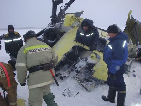 Emergencies Ministry members work at the site of a Mi-8 helicopter crash near the town of Igarka in Krasnoyarsk region, Russia, November 26, 2015. A Mi-8 helicopter carrying employees of Russia's state oil company Rosneft crashed in the Krasnoyarsk region in Siberia on Thursday, regional transport prosecutors said. REUTERS/Russia's Emergencies Ministry in Krasnoyarsk region/Handout ATTENTION EDITORS - THIS IMAGE HAS BEEN SUPPLIED BY A THIRD PARTY. IT IS DISTRIBUTED, EXACTLY AS RECEIVED BY REUTERS, AS A SERVICE TO CLIENTS. FOR EDITORIAL USE ONLY. REUTERS IS UNABLE TO INDEPENDENTLY VERIFY THE AUTHENTICITY, CONTENT, LOCATION OR DATE OF THIS IMAGE. NOT FOR SALE FOR MARKETING OR ADVERTISING CAMPAIGNS. NO RESALES. NO ARCHIVE.