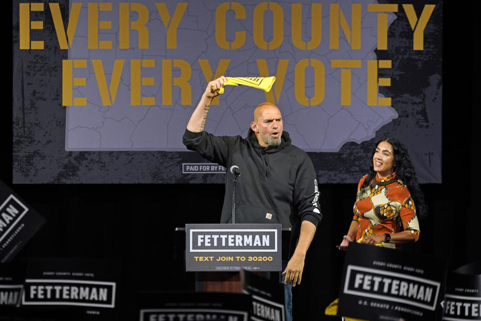 Pennsylvania Lt. Gov. John Fetterman, the Democratic nominee for the state's U.S. Senate seat, waves a towel after being introduced by wife Gisele Barreto Fetterman, right, during a rally in Erie, Pa., on Friday, Aug. 12, 2022. (AP Photo/Gene J. Puskar)