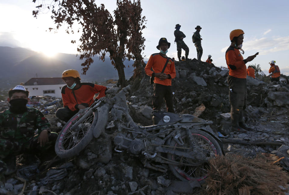 Rescue workers rest during a search for victims of Sept. 28 earthquake at Balaroa neighborhood in Palu, Central Sulawesi, Indonesia, Wednesday, Oct. 10, 2018. Indonesia's disaster agency said Wednesday that it only needs tents, water treatment units, generators and transport from other countries as it responds to the Sulawesi earthquake and tsunami that killed more than 2,000 people. (AP Photo/Dita Alangkara)