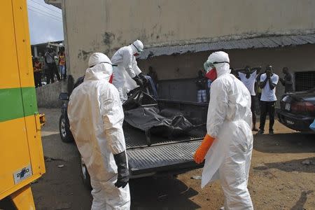 Health workers remove the body of Prince Nyentee, a 29-year-old man whom local residents said died of Ebola virus in Monrovia September 11, 2014. REUTERS/James Giahyue