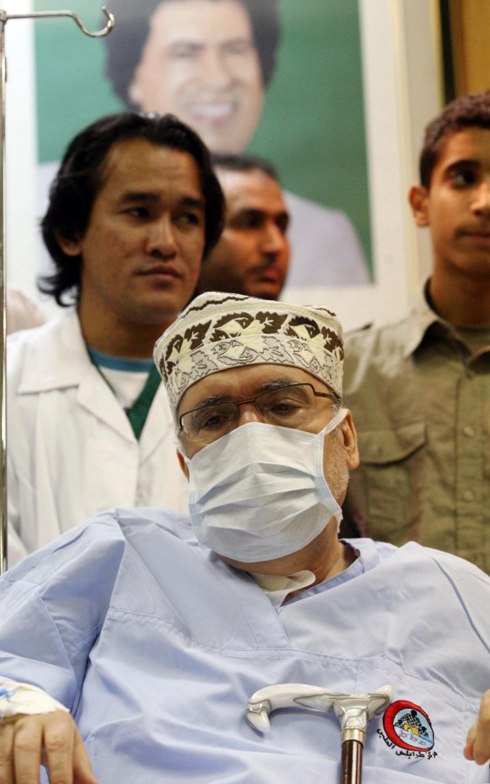 Abdelbaset Ali Mohmet al-Megrahi wears a medical mask as he sits on a wheelchair during a meeting with an African Delegation at a hospital in Tripoli on September 9, 2009 -  MAHMUD TURKIA/AFP