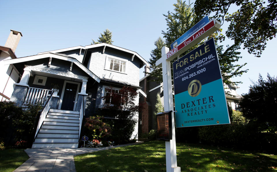 A real estate for sale sign is pictured in front of a home in Vancouver, British Columbia