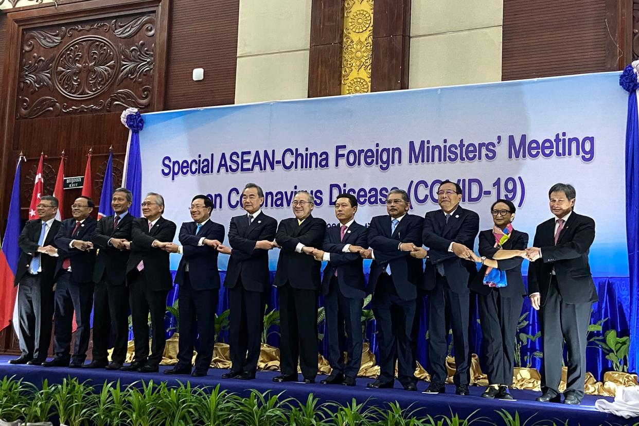 (L-R) Malaysia's Foreign Minister Saifuddin Abdullah, Myanmar's Union Minister for International Cooperation Kyaw Tin, Singapore's Foreign Minister Vivian Balakrishnan, Thailand's Foreign Minister Don Pramudwinai, Vietnam's Foreign Minister Pham Binh Minh, China's Foreign Minister Wang Yi, Philippines' Foreign Minister Teodoro Locsin Jr, Laos' Foreign Minister Saleumxay Kommasith, Brunei's Second Minister of Foreign Affairs Erywan Yusof, Cambodia's Foreign Minister Prak Sokhon, Indonesias Foreign Minister Retno Marsudi, and ASEAN Secretary-General Lim Jock Hoi shake hands on stage at a summit between China and ASEAN (Association of Southeast Asian Nations) on the COVID-19 coronavirus in Vientiane on February 20, 2020. - The deadly coronavirus is set to dominate the agenda of a high-level Vientiane summit February 20, as China's foreign minister meets with his Southeast Asian counterparts whose countries' economies have been hard-hit over fears of widespread contagion. (Photo by Dene-Hern Chen / AFP) (Photo by DENE-HERN CHEN/AFP via Getty Images)