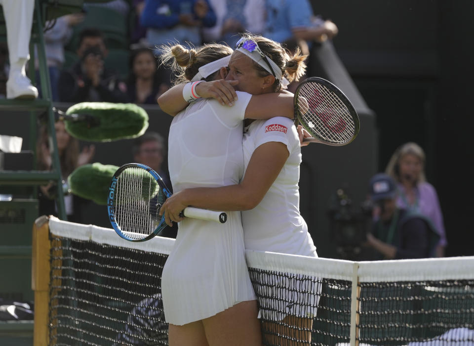 Belgium's Kirsten Flipkens hugs Romania's Simona Halep at the end of their second round women's single match on day four of the Wimbledon tennis championships in London, Thursday, June 30, 2022. (AP Photo/Alastair Grant)