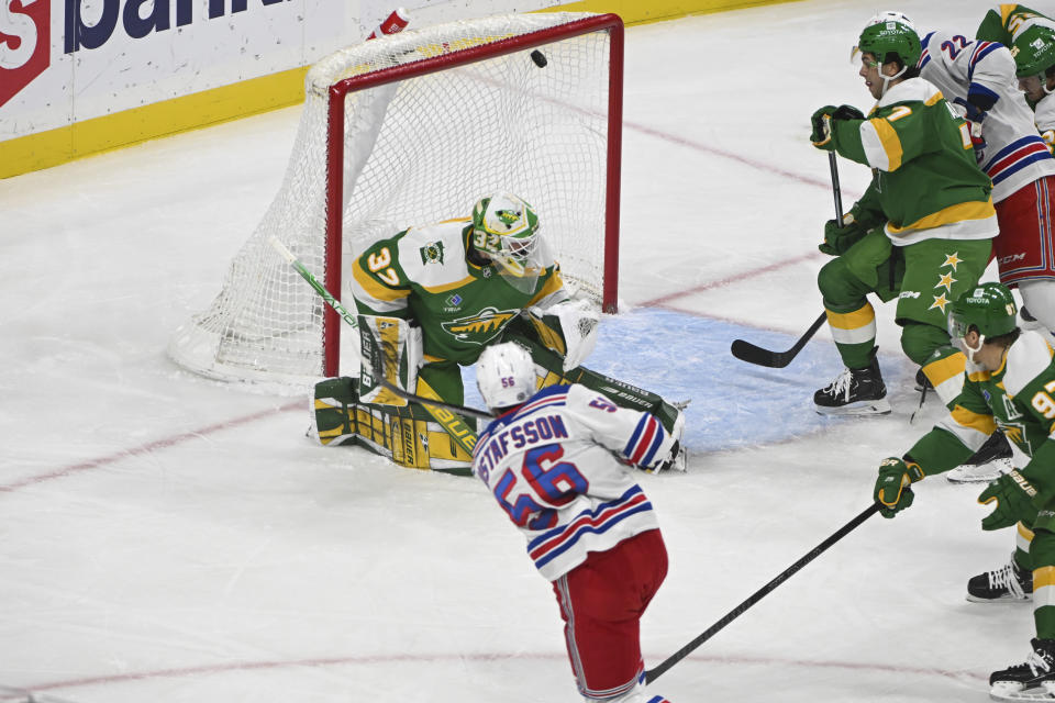 New York Rangers defenseman Erik Gustafsson (56) hits the puck past Minnesota Wild goalie Filip Gustavsson (32) to score during the first period of an NHL hockey game Saturday, Nov. 4, 2023, in St. Paul, Minn. (AP Photo/Craig Lassig)