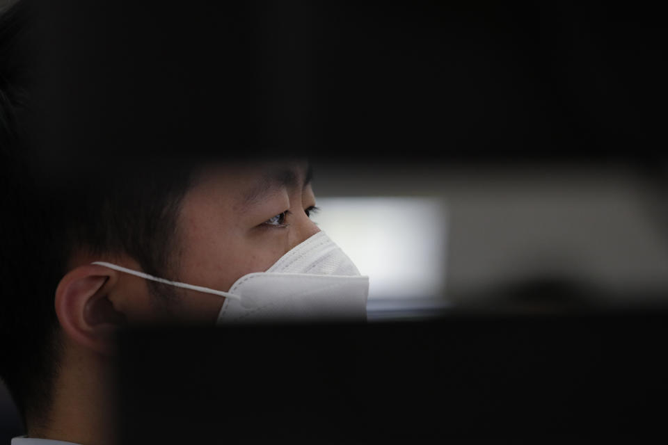 An employee of a bank wearing a face mask watches the computer monitors at the foreign exchange dealing room in Seoul, South Korea, Thursday, April 16, 2020. Asian stocks were mostly lower Thursday after unexpectedly weak U.S. retail and other data added to gloom about the impact of the coronavirus pandemic. (AP Photo/Lee Jin-man)