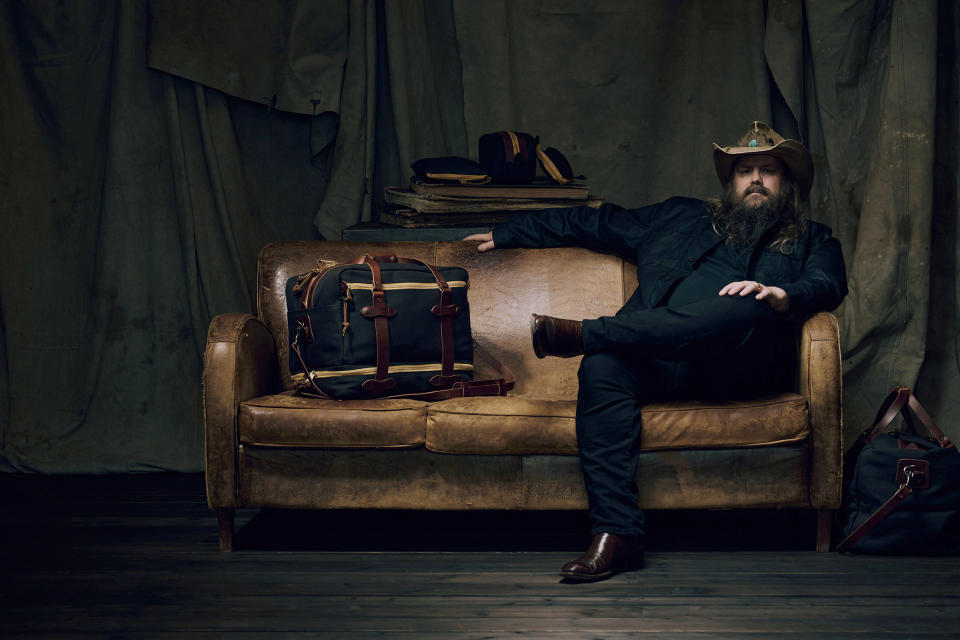 singer Chris Stapleton sits on a couch with his filson luggage