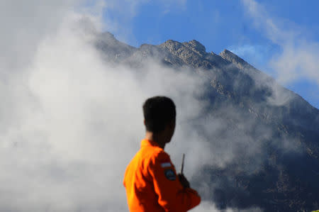 An officer from the National Search and Rescue Agency looks at Mount Merapi following a series of minor eruptions in Selo, Boyolali Regency, Central Java, Indonesia May 22, 2018 in this photo taken by Antara Foto. Antara Foto/Aloysius Jarot Nugroho/via REUTERS