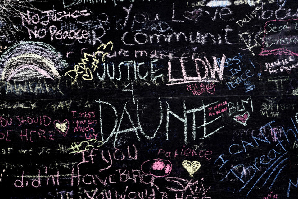 FILE - This April 22, 2021 file photo shows a chalkboard near a makeshift memorial in Brooklyn Center, Minn., near the site of the fatal shooting of Daunte Wright by a police officer during a traffic stop. Minnesota Attorney General Keith Ellison says his office will lead the prosecution of former Brooklyn Center Officer Kim Potter who is charged with second-degree manslaughter in the death of Daunte Wright. Potter, who is white, fatally shot Wright, a 20-year-old Black motorist, on April 11, 2021. (AP Photo/Morry Gash, File)