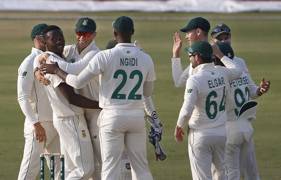 South Africa's pacer Kagiso Rabada, second left, celebrates with teammates after taking the wicket of Pakistan's batsman Imran Butt during the first day of the first cricket test match between Pakistan and South Africa at the National Stadium, in Karachi, Pakistan, Tuesday, Jan. 26, 2021. (AP Photo/Anjum Naveed)