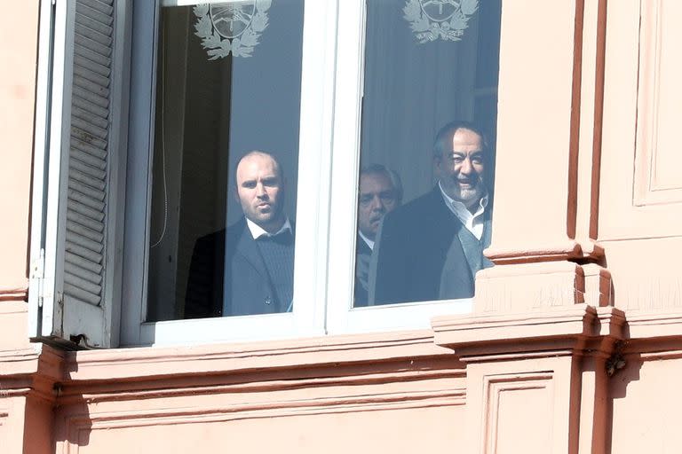 Martín Guzmán, Alberto Fernández y Héctor Daer se asoman desde una ventana de la Casa Rosada antes del anuncio por el cambio en Ganancias