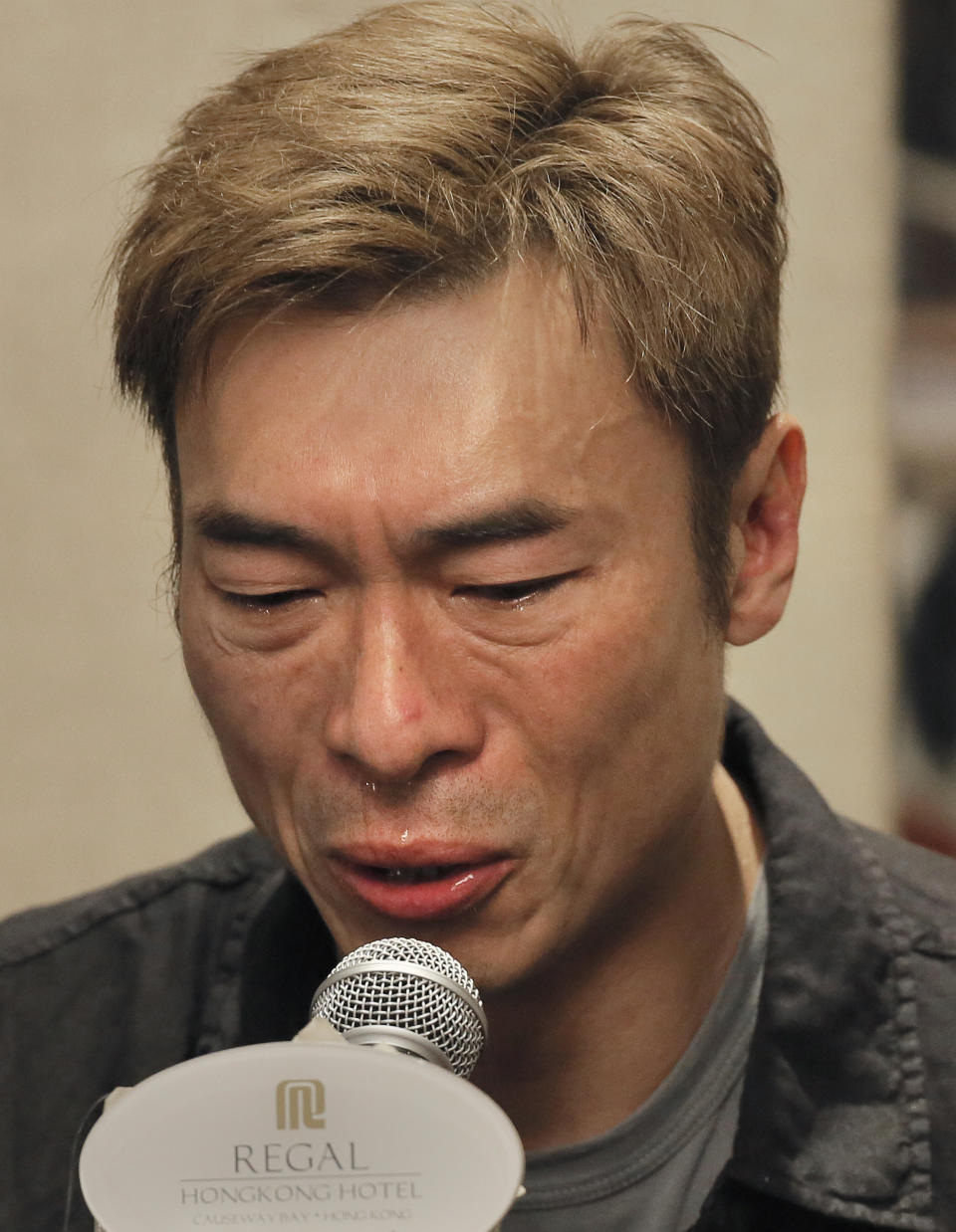 Hong Kong singer Andy Hui reacts at the press conference in Hong Kong, Tuesday, April 16, 2019. Hong Kong's Apple Daily newspaper published video that purported to show Andy Hui being intimate in a taxi with another Hong actress, decades younger than him, Jacqueline Wong. (AP Photo/Vincent Yu)
