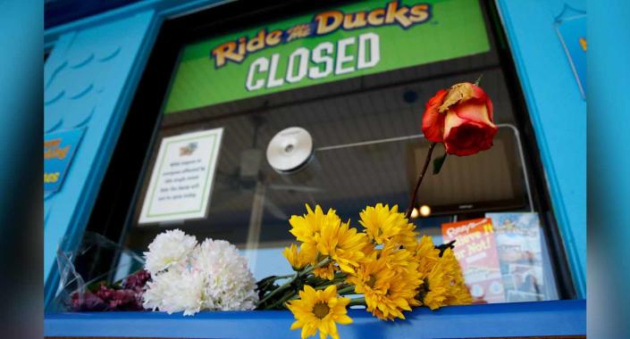 Flowers left by mourners rest on the ticket counter at the closed Ride the Ducks attraction Saturday. Source: AP via AAP