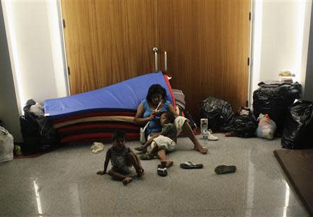 A mother and her two children camp out with others at a shelter in Acapulco September 20, 2013. REUTERS/Henry Romero