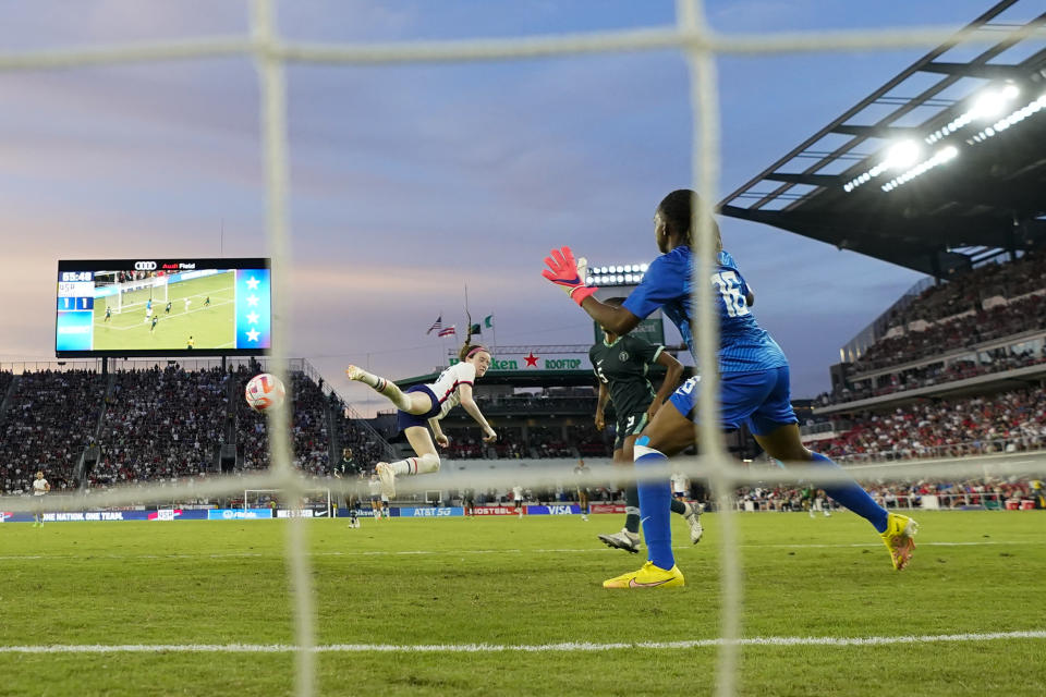 United States' Rose Lavelle, left, connects on a header while scoring a goal in front of Nigeria goalkeeper Chiamaka Nnadozie, right, and Blessing Demehin during the second half of an international friendly soccer match, Tuesday, Sept. 6, 2022, in Washington. The U.S. won 2-1. (AP Photo/Julio Cortez)