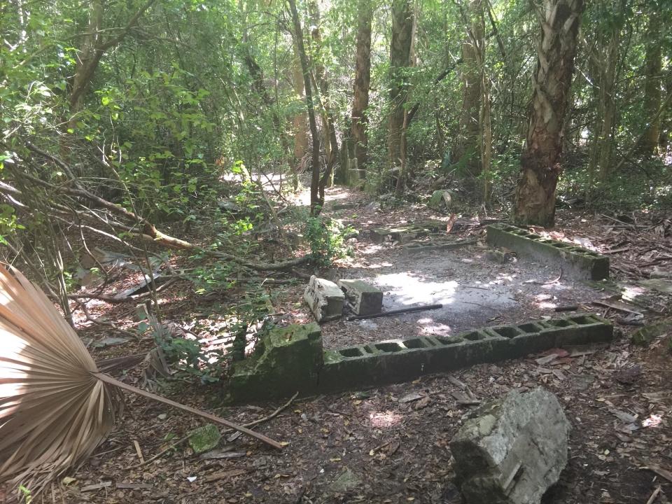 A knocked over structure in the middle of a woods